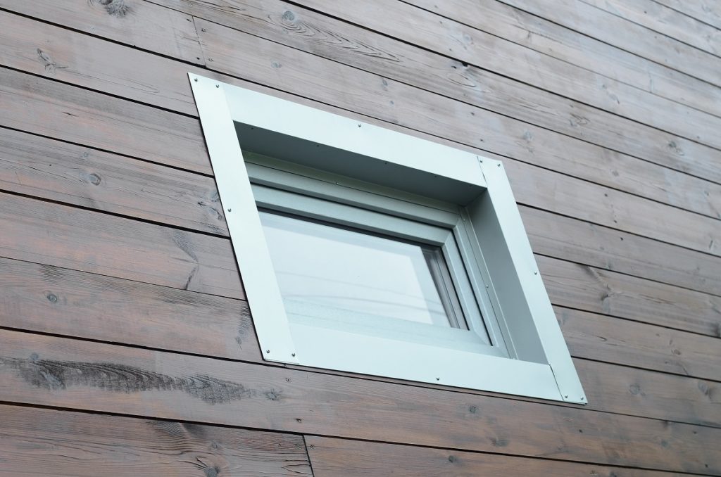 Plastic PVC window in modern passive wooden house facade wall. PVC windows are the number one in house energy efficiency